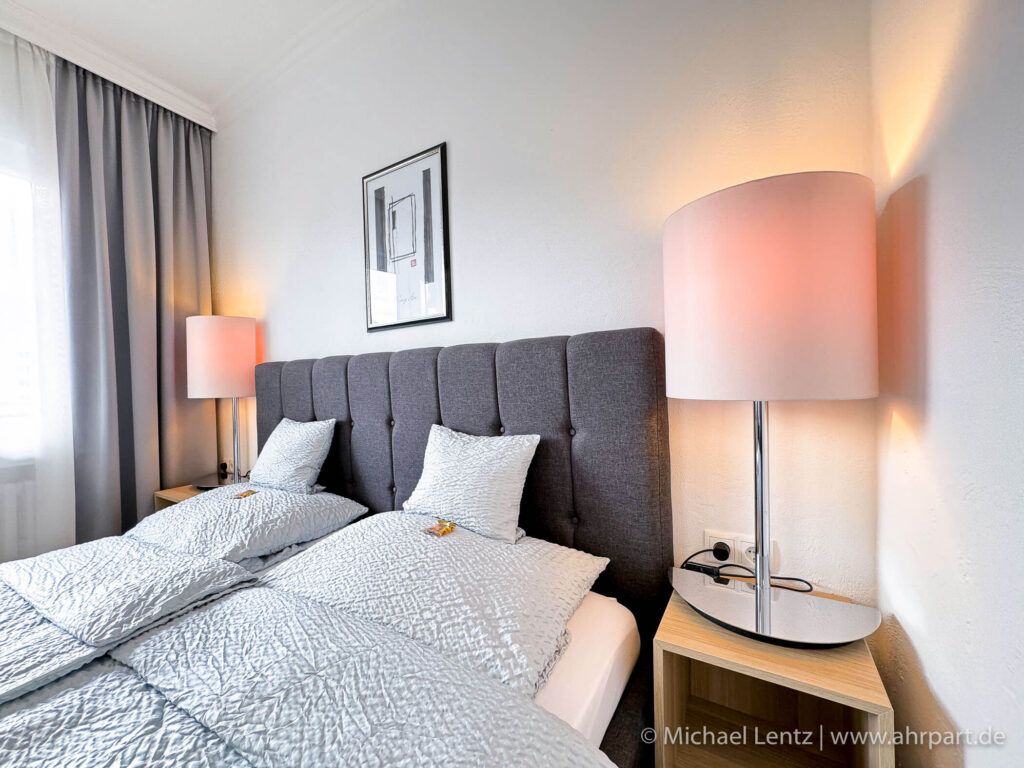 Großes Doppelbett eines Komfort Doppelzimmer im AHRPART Hotel. Hier wachsen sie morgens mit Blick auf die Ahr und das Kurhaus auf.