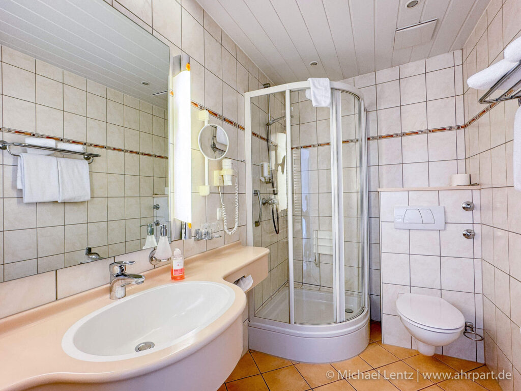 Badezimmer der Komfort Doppelzimmer am AHRPART Hotel mit Dusche/WC, Waschbecken, Haarföhn und frischen Handtüchern sowie Seife & Shampoo
